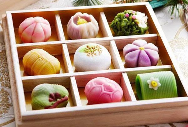 SỰ THẬT TỪ CHIẾC BÁNH MOCHI NHẬT BẢN LÀ GÌ? Ở Nhật có rất nhiều loại bánh kẹo khác nhau. Cũng có những loại bánh kẹo được dùng như là món ăn trong các dịp chúc mừng, dịp thời tiết thay đổi, cũng có những loại bánh kẹo là đặc sản của các địa phương. Cũng không hiếm những loại bánh với kiểu dáng mang tính nghệ thuật cao thể hiện vẻ đẹp của tự nhiên và thời tiết. Lần này, tôi xin giới thiệu tới các bạn l loại bánh vô cùng nổi tiếng của người Nhật đó là bánh Mochi. Trong văn hóa Nhật Bản, bánh mochi với ý nghĩa viên mãn và thường được dâng lên thần linh vào những lễ hội quan trọng. Bánh mochi không chỉ ngon mà còn nhiều sự thật thú vị khác chờ bạn khám phá! Tìm Hiểu Về Mochi Và Nguồn Gốc Bánh mochi hay còn gọi là bánh dày Nhật Bản là món bánh được làm từ gạo nấu lên rồi giã đều sau đó nặn thành bánh. Mọi người thông thường sẽ nhìn thấy bánh mochi có dạng tròn và có kích cỡ khoảng một nấm tay. Tuy nhiên, tùy thuộc vào từng mùa và từng lễ hội đặc biệt trong văn hóa Nhật Bản sẽ cho ra đời các bánh mochi có hình dạng khác nhau.    ( Mâm bánh mochi đầy màu sắc ngày lễ ) Đối với những ai muốn tìm mua bánh kẹo Nhật Bản về làm quà thì không thể nào bỏ lỡ những chiếc bánh mochi xinh xắn, thơm ngon. Nhìn chung, hình dáng của mochi được bán ngoài các cửa hàng khá bắt mắt. Nhân bánh lại càng đa dạng, phong phú hơn. Đó có thể là nhân đậu đỏ truyền thống, nhân kem tươi với đầy đủ các mùi vị cho bạn cơ hội thưởng thức những chiếc bánh có lớp vỏ ngoài mềm dẻo với phần nhân ngọt thanh.  ( Cách giã bánh truyên thống ) Theo tương truyền, mochi có nguồn gốc từ Trung Quốc. Ban đầu chỉ là bánh gạo nếp trộn với đậu đỏ và chỉ dành cho giới quý tộc, thượng lưu thời đó thưởng thức. Thiên Hoàng Nhật Bản khi đó rất yêu thích món bánh này đồng thời xem chúng như một điềm lành và sự thịnh vượng cho quốc gia.  ( Bánh mochi nhân đậu đỏ truyền thống ) Mãi về sau khi Nhật Bản phát triển hơn thì bánh mochi đã tiếp cận được toàn bộ người dân trên cả nước. Trải qua hàng trăm năm kể từ khi ra đời, mochi vẫn luôn được người Nhật ưu ái thưởng thức như một món ăn Nhật Bản truyền thống. Đồng thời, họ còn kính dâng lên các vị thần linh trong văn hóa Nhật Bản vào các lễ hội quan trọng như chào đón năm mới, tết Trung thu… Lễ hội Mochitsuki 10/10 Văn hóa Nhật Bản luôn có những lễ hội độc đáo khiến nhiều người tròn xoe mắt. Ngày 10/10 hằng năm là ngày hội bánh mochi hay còn gọi là Mochitsuki. Nếu để ý, bạn sẽ thấy lễ hội Nhật Bản này trùng với ngày Hội thể thao toàn quốc. Thực chất, chúng mang một ý nghĩa sâu sắc và kết nối với nhau. ( Bánh mochi nhân matcha thơm lừng ) Từ thời xa xưa, người ta đã biết áp dụng các món ăn Nhật Bản dinh dưỡng vào cuộc sống với tùy các mục đích khác nhau. Đối với các vận động viên điền kinh, bơi lội, bóng chày hay bất kỳ môn thể thao nào cũng đều cần nạp năng lượng tối đa để chiến thắng. Vì thế, không thể bỏ lỡ chiếc bánh mochi thơm ngon, chứa nhiều năng lượng có lợi để tăng cường sức khỏe. Người dân và chính phủ đã quyết định chọn ngày hội thể thao là lễ hội Nhật Bản Mochitsuki. Ý Nghĩa Của Bánh Mochi Trong Văn Hóa Nhật Bản Hầu hết, người dân xứ Phù Tang luôn yêu thích các món ăn Nhật Bản có dạng hình tròn. Vì theo quan niệm từ xa xưa, hình tròn tượng trưng cho sự trọn vẹn, no đầy trong cuộc sống, công việc và tiền tài. Họ tuyệt nhiên tránh xa những hình tượng vật nhọn hay góc cạnh. Cũng chính vì điều này nên mochi được chọn là món bánh kẹo Nhật Bản quen thuộc để dâng lên các vị thần tối cao.  ( Một dáng bánh mochi nướng với mùi thơm đặc biệt) Trong ngày Tết Trung thu Nhật Bản, bạn sẽ trông thấy trước hiên nhà có các mâm bánh được chất đầy những chiếc bánh mochi tròn tròn, nhỏ nhỏ. Mâm bánh được sắp xếp theo dạng kim tự tháp để cầu mong cho một mùa màng mới được bội thu, nhân dân no ấm.  Phân Biệt Các Loại Bánh Mochi Tại Nhật Bản Daifuku Daifuku là bánh mochi truyền thống nhất tại Nhật Bản với lớp vỏ ngoài dày và bên trong là nhân đậu đỏ thơm ngon. Bánh này được bán tại khắp mọi nơi trong các cửa hàng bánh kẹo Nhật Bản. Nếu bạn muốn thưởng thức mochi nguyên bản thì nhất định không thể bỏ lỡ Daifuku đâu nhé! Tiệm bánh mochi bán đầy các hương vị Ichigo Daifuku Tương tự với Daifuku, Ichigo Daifuku có phần nhân bên trong là miếng dâu tây căng mọng. Cắn vào một miếng bạn sẽ cảm nhận được vị bánh độc đáo với độ ngọt và vị chua vừa phải, ngon tuyệt vời. Ichigo Daifuku được nhiều người thích mê  Sakuramochi Chắc hẳn nghe đến tên thì nhiều người đã đoán được phần nào món bánh mochi xinh xắn này. Sakuramochi được người Nhật thưởng thức trong dịp Hanami - lễ hội ngắm hoa anh đào. Khác với những chiếc bánh hình tròn quen thuộc, Sakuramochi được cuộn nhỏ với lớp vỏ mỏng và bên trong là nhân đậu đỏ ngọt thanh. Warabi Mochi "Nhìn thôi đã muốn thưởng thức ngay" - là câu nói mà nhiều người khi bắt gặp đĩa bánh Warabi mochi. Độc đáo nhất phải kể đến thành phần nguyên liệu bao gồm bột dương xỉ và phủ đầy bởi lớp bột đậu nành nướng Kinako.  Dango Dango là món bánh không còn xa lạ đối với mọi người nhất là những người yêu văn hóa Nhật Bản. Tuy vậy, vẫn có không ít bạn lầm tưởng dango và mochi là 2 loại bánh khác nhau. Nhưng Dango chính xác là một trong những loại bánh nổi tiếng của mochi được người dân và du khách yêu thích.                                                   Xiên dango xinh xắn ai cũng thích Mochi Kem Món ăn Nhật Bản được nhiều bạn trẻ Việt Nam yêu thích chính là Mochi kem. Lớp vỏ ngoài mỏng dẻo dẻo cùng nhân kem lạnh bên trong cực kỳ sảng khoái, mang đến cho bạn trải nghiệm ngày hè ngon khó cưỡng. Ngoài ra, vẫn còn khá nhiều loại bánh mochi khác được bán tại Nhật Bản cho bạn tha hồ chọn lựa về làm quà. Mochi là chiếc bánh có ý nghĩa cực kỳ quan trọng trong văn hóa Nhật Bản. Đồng thời, chúng đại diện cho những giá trị lớn lao mà người Nhật đã đưa vào từng chiếc bánh.  Bánh Mochi hương vị đặc trưng tại Nhật Bản, Bạn nên thưởng thức một lần.,